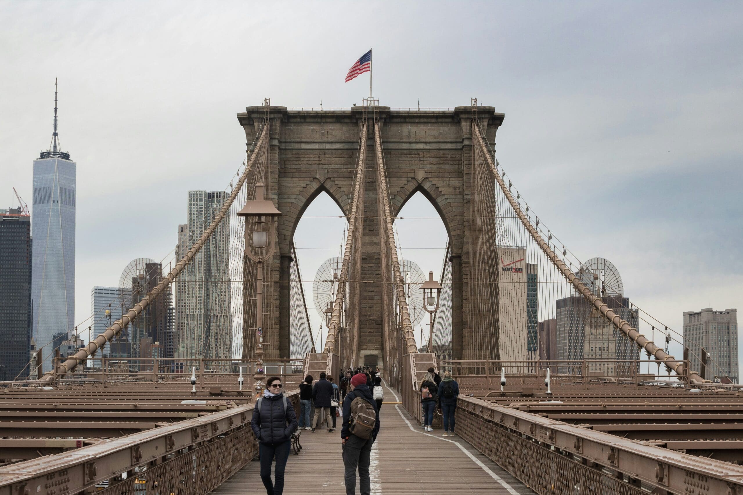 People walking across the Brooklyn Bridge in New York City during the fall
